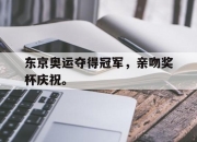 半岛体育-东京奥运夺得冠军，亲吻奖杯庆祝。